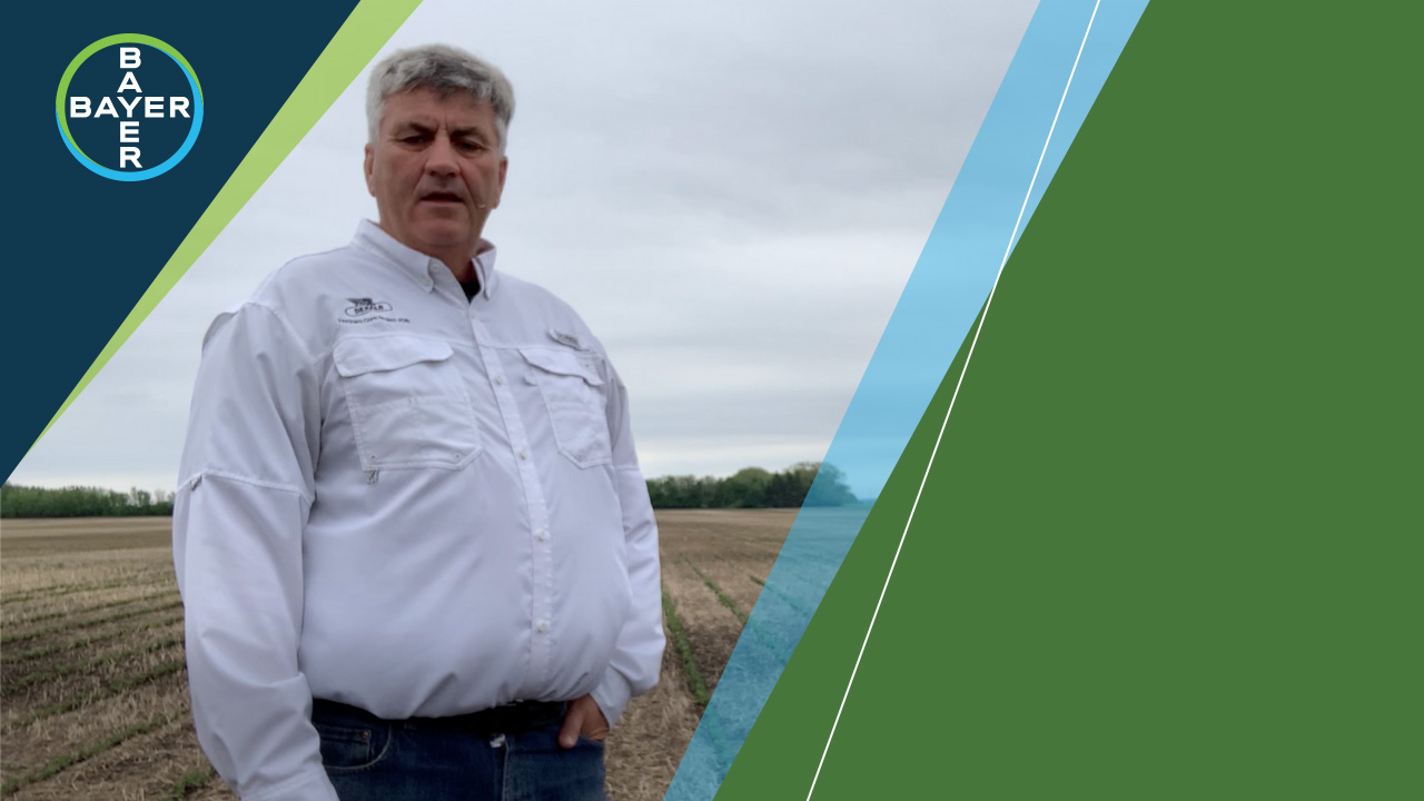 Image of Bruce Murray standing in a field talking about controlling early weeds with Roundup Xtend and Xtendimax.